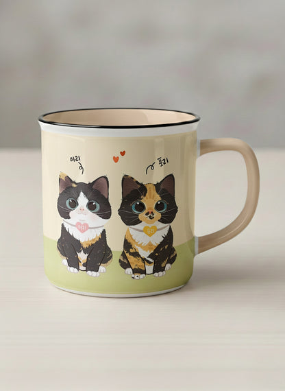 Enamel mug | Our Precious Pair mug, two adorable tuxedo cats side by side with Korean name tags and tiny red hearts, soft cream interior and handle, by Hyun Jung Cho - Gallery By Inhesion