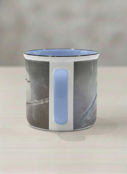 enamel mug | A Moment in the Snow side view mug, a fluffy white bird perched quietly in a soft wintry haze, sky blue interior and handle, by Karina Mosser - Gallery By Inhesion