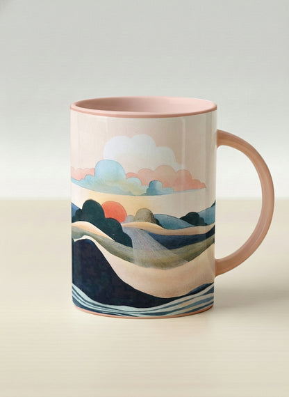 Hero mug | Sunset at the River mug rolling hills and dark treetops beneath a soft peach sky with blush and teal clouds and a glowing setting sun, warm peach interior and handle, by KikaG - Gallery By Inhesion