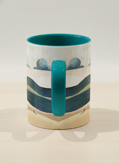 hero mug  | Share a Sunset side view mug a lone figure walking through rolling sand dunes beneath a glowing orange sun and layered teal clouds, deep teal interior and handle, by KikaG - Gallery By Inhesion