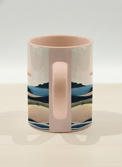 hero mug | Sunset at the River side view mug rolling hills and dark treetops beneath a soft peach sky with blush and teal clouds and a glowing setting sun, warm peach interior and handle, by KikaG - Gallery By Inhesion