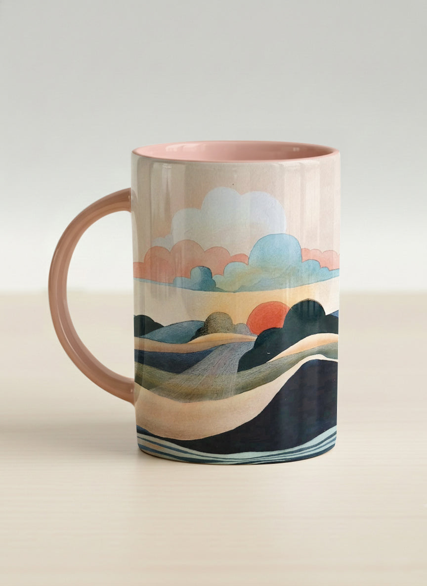 hero mug | Sunset at the River left view mug rolling hills and dark treetops beneath a soft peach sky with blush and teal clouds and a glowing setting sun, warm peach interior and handle, by KikaG - Gallery By Inhesion