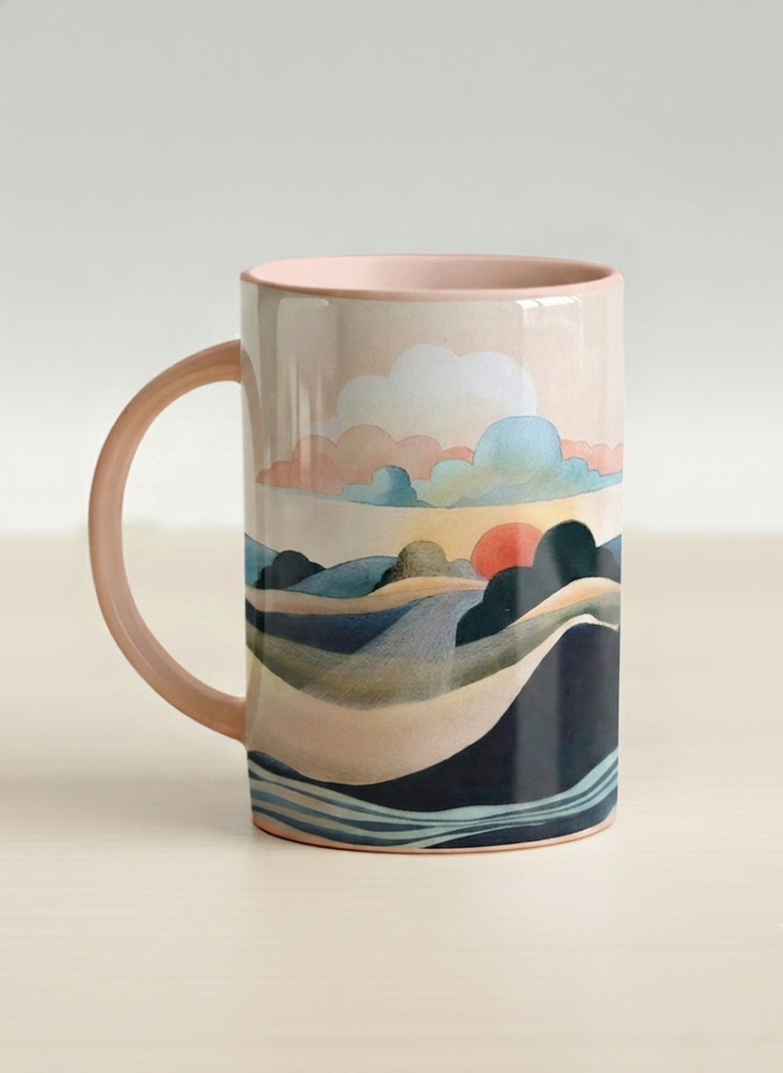 hero mug | Sunset at the River left view mug rolling hills and dark treetops beneath a soft peach sky with blush and teal clouds and a glowing setting sun, warm peach interior and handle, by KikaG - Gallery By Inhesion