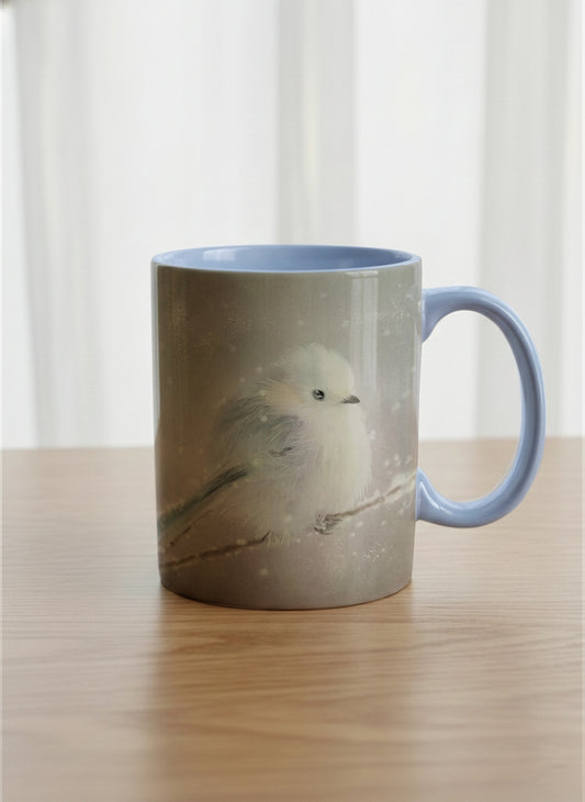 classic mug | A Moment in the Snow mug, a fluffy white bird perched quietly in a soft wintry haze, sky blue interior and handle, by Karina Mosser - Gallery By Inhesion