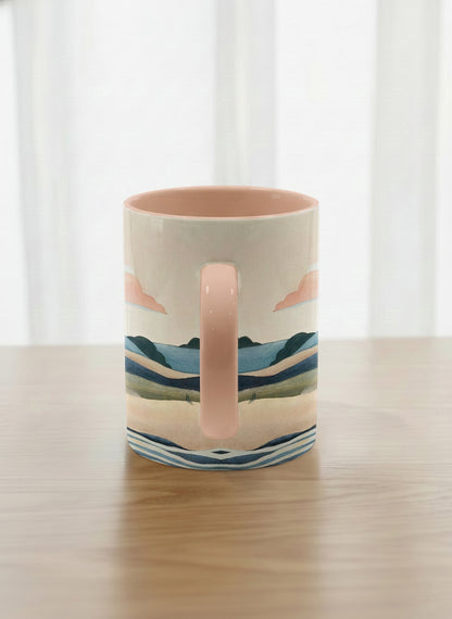 classic mug | Sunset at the River side view mug rolling hills and dark treetops beneath a soft peach sky with blush and teal clouds and a glowing setting sun, warm peach interior and handle, by KikaG - Gallery By Inhesion