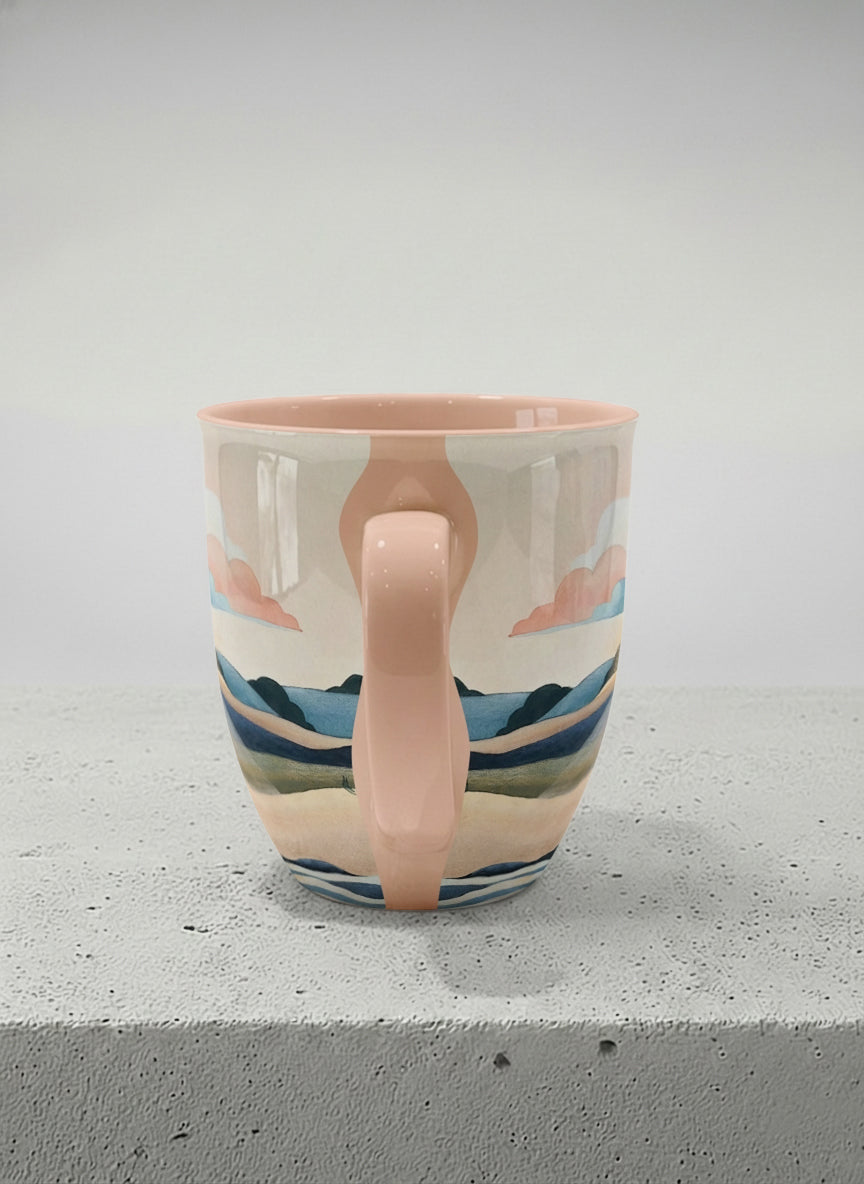 Ronny mug | Sunset at the River side view mug rolling hills and dark treetops beneath a soft peach sky with blush and teal clouds and a glowing setting sun, warm peach interior and handle, by KikaG - Gallery By Inhesion