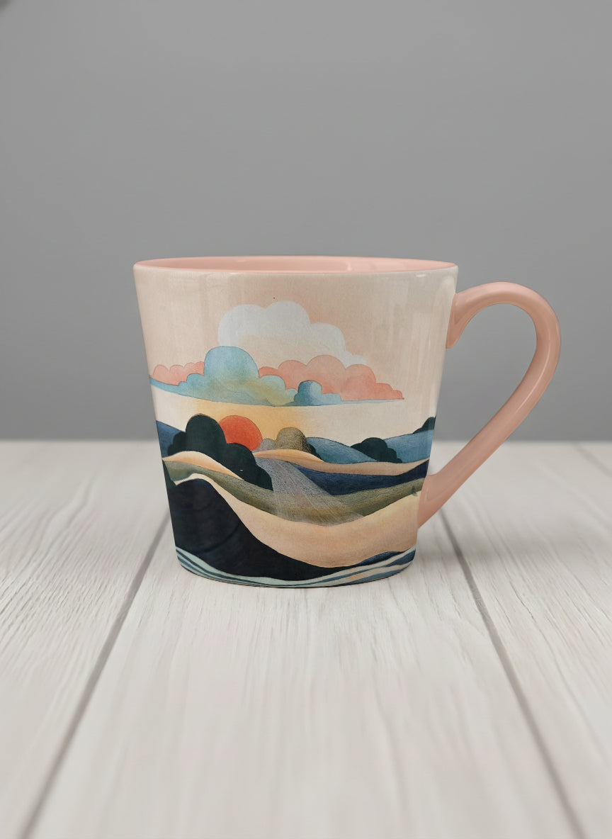 conical mug | Sunset at the River mug rolling hills and dark treetops beneath a soft peach sky with blush and teal clouds and a glowing setting sun, warm peach interior and handle, by KikaG - Gallery By Inhesion