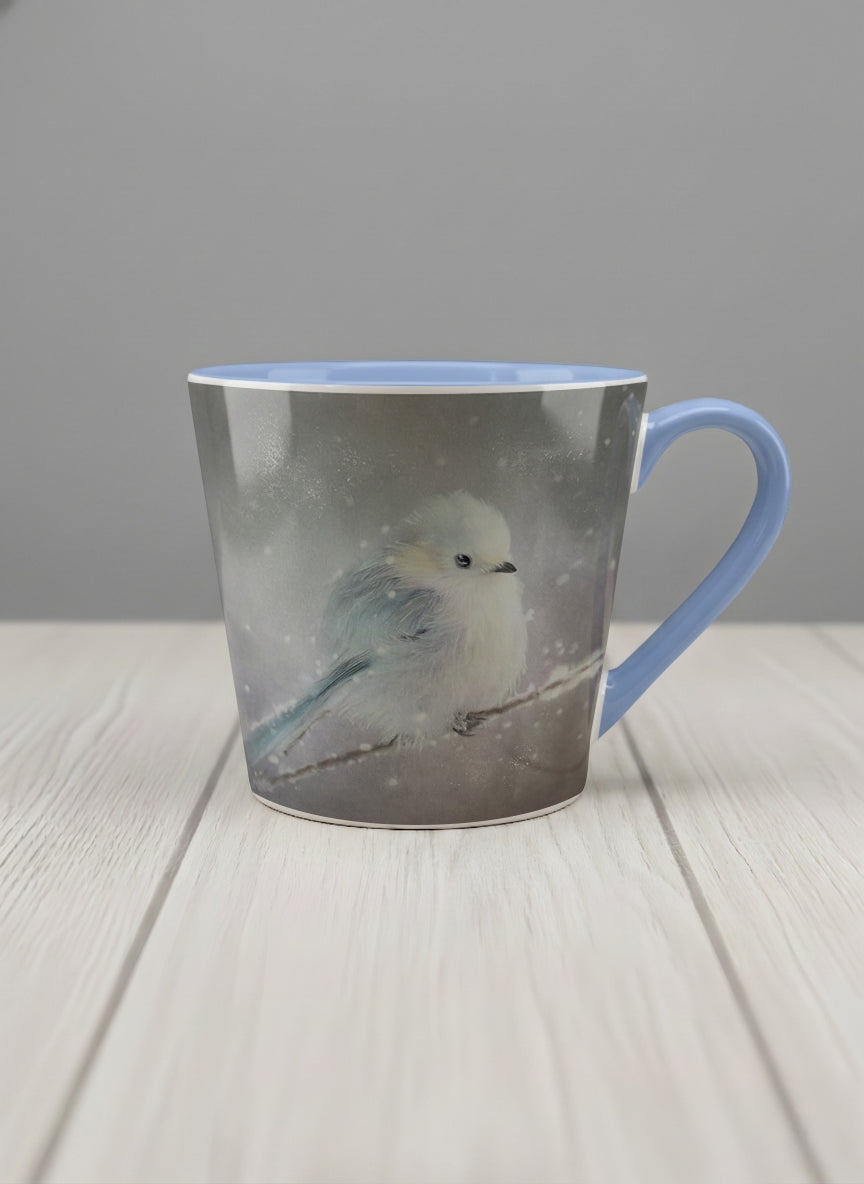 conical mug | A Moment in the Snow mug, a fluffy white bird perched quietly in a soft wintry haze, sky blue interior and handle, by Karina Mosser - Gallery By Inhesion