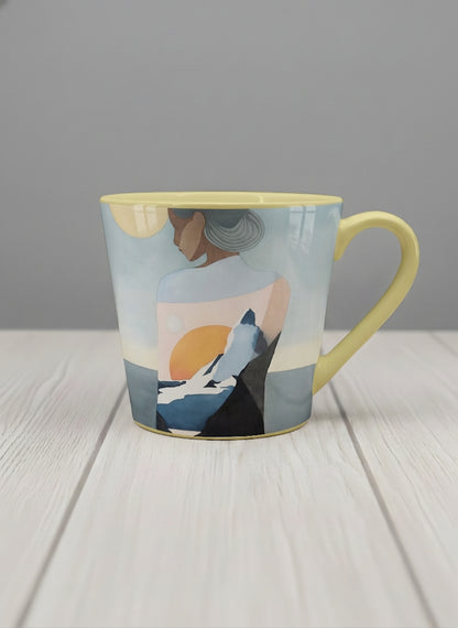 Conical mug | A Mountain to Climb mug woman gazing over jagged peaks and a golden sun on teal horizon, butter yellow interior, by KikaG - Gallery By Inhesion
