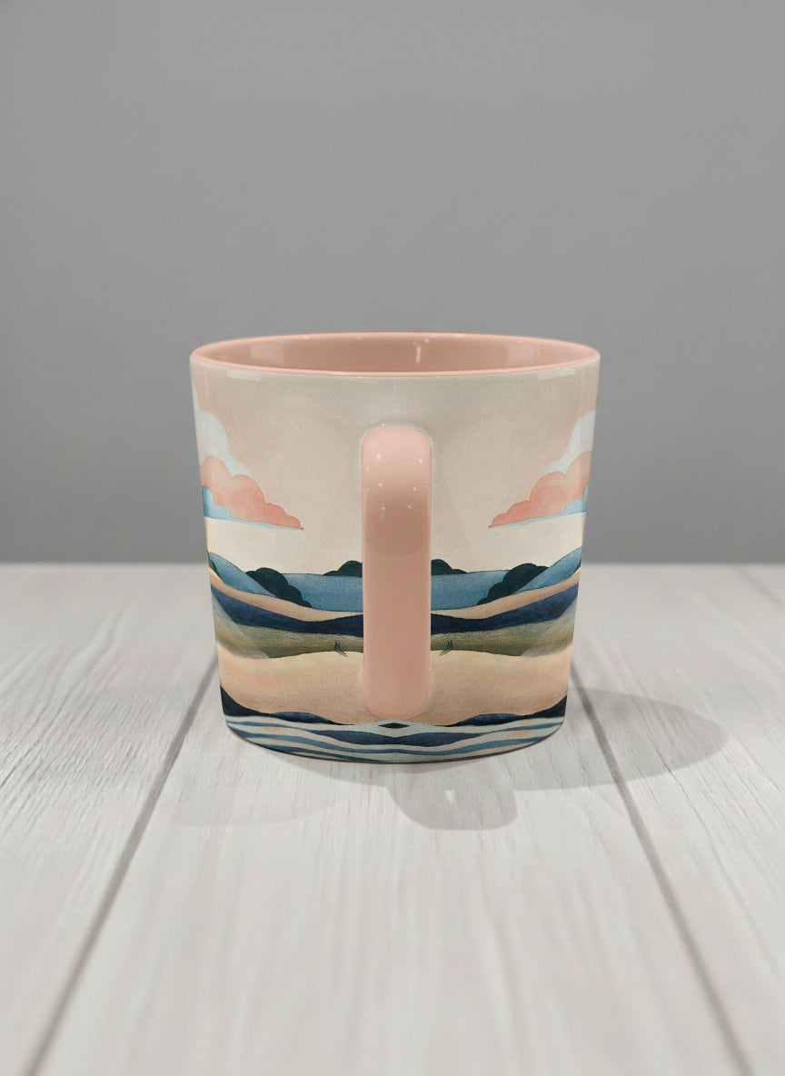 conical mug | Sunset at the River side view mug rolling hills and dark treetops beneath a soft peach sky with blush and teal clouds and a glowing setting sun, warm peach interior and handle, by KikaG - Gallery By Inhesion