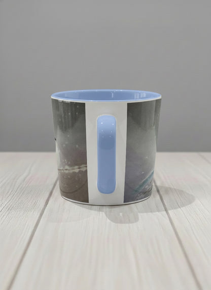 conical mug | A Moment in the Snow side view mug, a fluffy white bird perched quietly in a soft wintry haze, sky blue interior and handle, by Karina Mosser - Gallery By Inhesion
