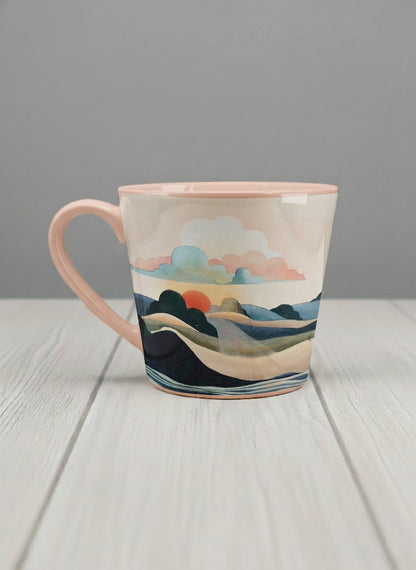 Conical mug | Sunset at the River left view mug rolling hills and dark treetops beneath a soft peach sky with blush and teal clouds and a glowing setting sun, warm peach interior and handle, by KikaG - Gallery By Inhesion