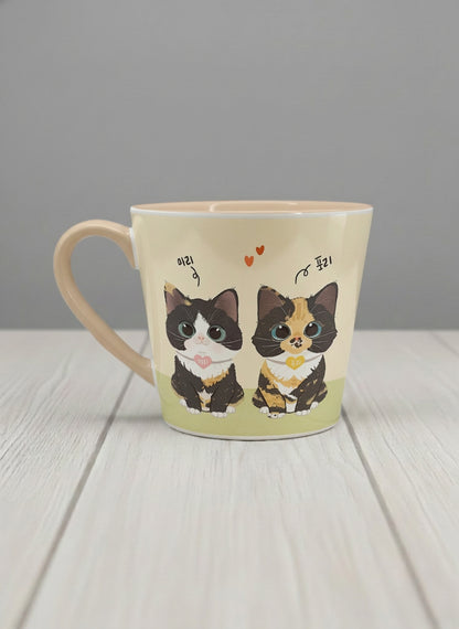 Conical mug | Our Precious Pair left view mug, two adorable tuxedo cats side by side with Korean name tags and tiny red hearts, soft cream interior and handle, by Hyun Jung Cho - Gallery By Inhesion