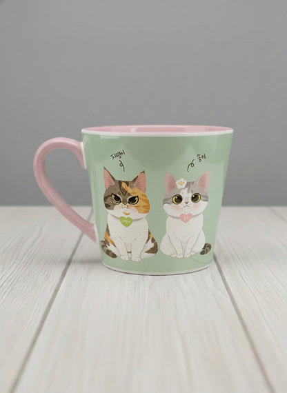 Conical Mug | The Perfect Pair left view mug two cats with Korean name tags and bow ties on mint green, blush pink interior, by Hyun Jung Cho